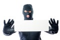Robber in black clothes and mask with a poster in hands Royalty Free Stock Photo