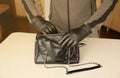 Robber in black outfit and gloves see on opened stolen women bag. A thief evaluates the value of stolen items from a