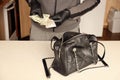 Robber in black outfit and gloves see in opened stolen women bag. The thief takes out US dollar bills from a womans handbag in Royalty Free Stock Photo