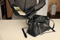 Robber in black outfit and gloves see in opened stolen women bag. The thief takes out US dollar bills from a womans handbag in Royalty Free Stock Photo