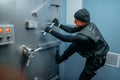 Robber in black uniform trying to break vault lock Royalty Free Stock Photo