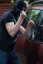 Robber breaks car window Royalty Free Stock Photo
