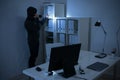 Robber With Flashlight Searching For Documents In Office