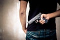 Robber hide gun in his back. Criminal and murder concept. Cross processing and split tone pinterest and instragram like process. Royalty Free Stock Photo