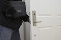 Robber Holding Laptop While Opening Door Of House Royalty Free Stock Photo