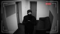 Robber in mask hacking surveillance camera in corporative building, criminal