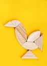 Robin redbreast figure is assembled from pieces of a tangram puzzle game over a yellow background