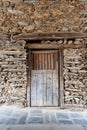 An old wooden door with an iron barred window and a wooden lintel in the town of Robledillo de Gata. Royalty Free Stock Photo