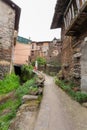 A narrow concrete street with large potted plants next to a stream that flows into the Arrago river