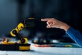 Robot arm touches human hand in science classroom