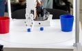 Robot automatic hand taking cubes and putting in glass. Automatic robotic arm Royalty Free Stock Photo