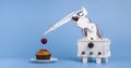 Robot cooking dessert, decorating sweet cupcake with fresh cherry