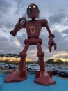 a robot on display on a parking lot by a building