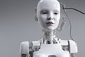 Robot in the form of a humanoid child, with a glossy white surface and visible metal wires