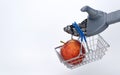 Robot hand holds a grocery basket with an apple. food delivery using artificial intelligence. contactless trading