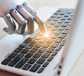 Robot hands and fingers point to laptop button advisor chatbot robotic artificial intelligence concept with light Royalty Free Stock Photo