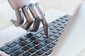 Robot hands and fingers point to laptop button advisor chatbot robotic artificial intelligence Royalty Free Stock Photo