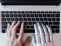 Robot hands and fingers point to laptop button advisor chatbot robotic artificial intelligence Royalty Free Stock Photo