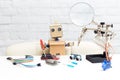 The robot with hands sits at the table and near the working tool