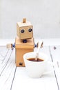 Robot holding a spoon and drinking coffee. Vertical photo