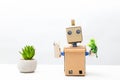 The robot holds a green plant in his hand. White background