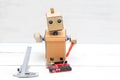 The robot holds a red screwdriver and a printed circuit board in