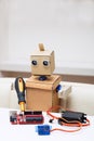 The robot holds a screwdriver and solder the red chip on the table