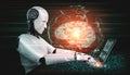 Robot humanoid use laptop and sit at table in concept of AI thinking brain Royalty Free Stock Photo