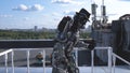 Robot moves his hands on background of city skyline and blue sky. Footage. Concept of technologies with artificial