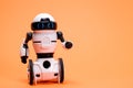 Robot on an orange background with a place for text for a toy store and children's technology centers. Royalty Free Stock Photo