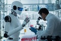 A robot and a scientist collaborate in a laboratory setting, analyzing samples Royalty Free Stock Photo