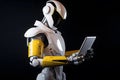 Robot studying information on a tablet on a black background.