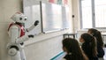 Robot teaching students at a whiteboard in a bright classroom Royalty Free Stock Photo