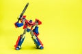 Robot transformer red and blue on yellow background with space for text. Toys for children, toy store. Royalty Free Stock Photo