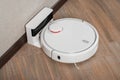 Robot vacuum cleaner on charging dock after it is finished. Modern smart electronic housekeeping technology