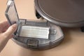 Robot Vacuum Cleaner Close Up. Woman cleans trash bin automatic robot vacuum cleaner Royalty Free Stock Photo