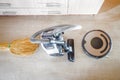 Robot vacuum cleaner with evil eyes and grin and regular vacuum cleaners side by side. Old versus new and technology evolution Royalty Free Stock Photo