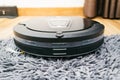 Robot vacuum cleaner on laminate wood and carpet. Royalty Free Stock Photo