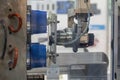 The robotic arm gripping the plastic container part at injection machine