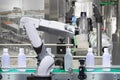 Robotic arm holding water bottles on drink production line