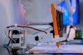 Robotic arm with orange pen drawing portrait at robot futuristic exhibition