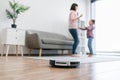 Robotic device collecting dust while mom and child dancing