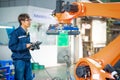 Robotic engineer is setting handling robot during installation automation system in workshop. Royalty Free Stock Photo