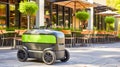 Robotic food delivery unit on a sidewalk near outdoor restaurant seating Royalty Free Stock Photo