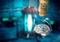 Robotic hand holding metal human brain in factory production line, artificial intelligence concept