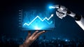 Futuristic robotic hand pointing at digital graph chart with upward trend on tablet against city skyline background Royalty Free Stock Photo
