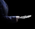 Robotic hand in suit shows outstretched hand.