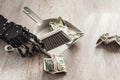 Robotic hand wielding a dustpan and brush, meticulously sweeping up one-dollar bills Royalty Free Stock Photo