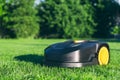 Robotic Lawn Mower cutting grass in the garden. Automatic robot lawnmower in modern garden on sunny day Royalty Free Stock Photo