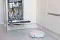 Robotic vacuum cleaner and dishwasher machine in kitchen Royalty Free Stock Photo